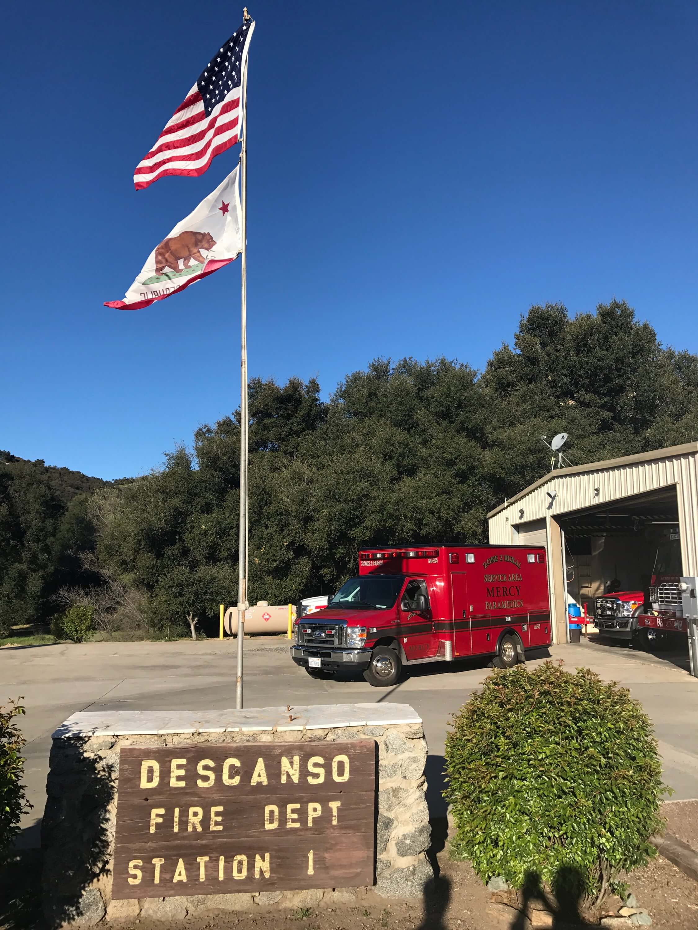 A Mercy Medical Transportation ambulance staged alongside a local fire department